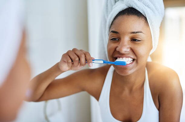 a woman brushing her teeth in front of a mirror