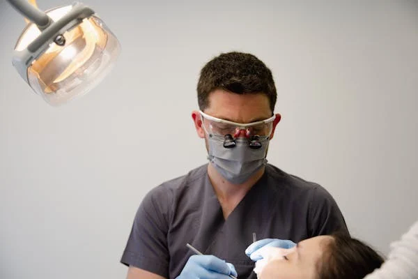 a male dental professional performing a dental treatment on a patient